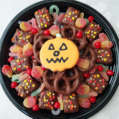 - Fall-themed edible gift platter with chocolate rice krispie pops, pretzels, sour candies, and a pumpkin sugar cookie